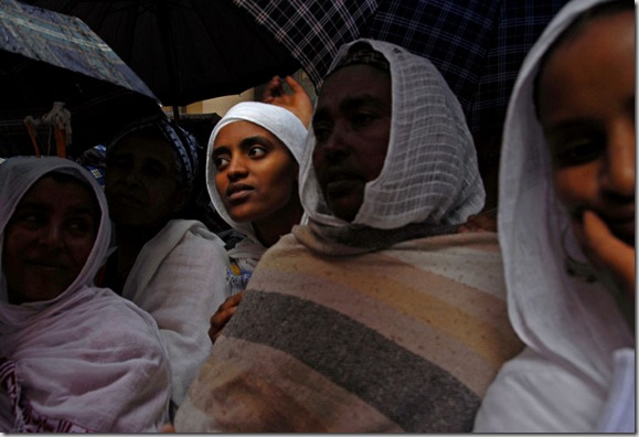 Women huddle together under umbrellas amidst throngs of worshippers on St. Teklehaymanot's Day at the Teklehaymanot Church in Addis Ababa on August 30, 2007.
