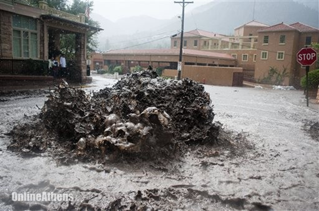 Flood water shoots out of a sewer on Canon Avenue on Thursday, 12 September 2013, in Manitou Springs, Colorado. Flash flooding in Colorado has cut off access to towns, closed the University of Colorado in Boulder and left at least three people dead. Photo: Michael Ciaglo / The Colorado Springs Gazette