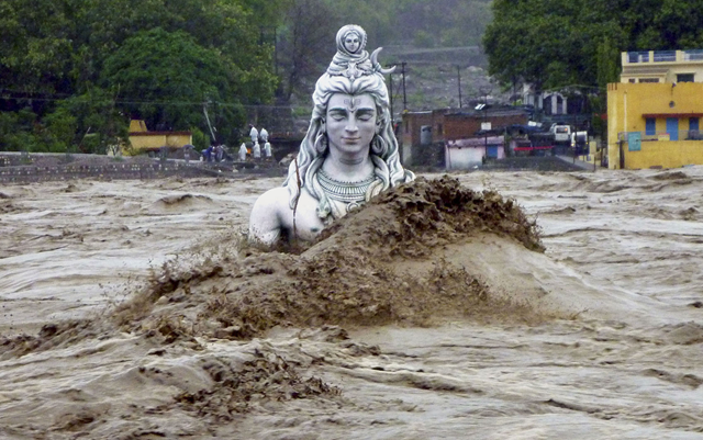 A submerged statue of the Hindu Lord Shiva stands amid the flooded waters of river Ganges at Rishikesh in the Himalayan state of Uttarakhand, 17 June 2013. Early monsoon rains have swollen the Ganges, India's longest river, swept away houses, killed at least 60 people and left tens of thousands stranded, officials said on 18 June 2013. Photo: REUTERS / Stringer
