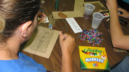 Missouri Hotel residents create bookmarks that have inspirational words on them.