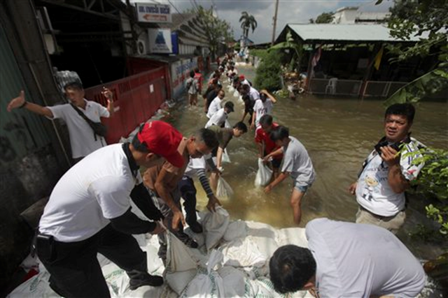 Thai soldiers and volunteers pass sandbags as they fortify an alley after swollen Chao Phraya river overflows in Bangkok, Thailand, Saturday, Oct. 29, 2011. The complex network of flood defenses erected to shield Thailand's capital from the country's worst floods in nearly 60 years was put to the test Saturday as coastal high tides hit their peak. Altaf Qadri / AP Photo