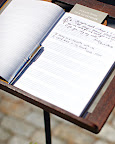 A guest book of sheet music perched on an antique music stand is a nod to the grooms' careers. A guest book of sheet music perched on an antique music stand is a nod to the grooms' careers.