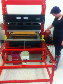 When we have done making paper, we take the post and put it in this 50-ton hydrolic press to squeeze out all the extra water.  This also presses the fibers together more to help form a stronger sheet.  Out of these large 12 sheets of paper, we can usually squeeze out about 10-15 gallons of water.
