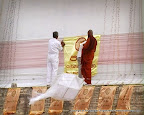 Hanging Ganana Kodi (Flags) around Pesa Walalu (outer rings of Ruwanweliseya stupa)
