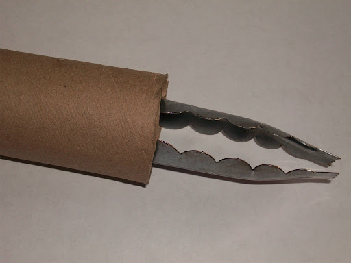 Kitchen tongs contained in a tube.