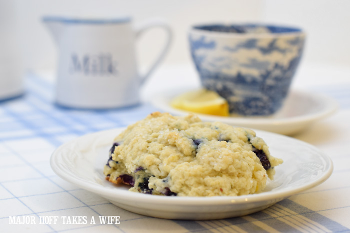A buttery blueberry scone is the perfect serving suggestion for High Tea. A melt in your mouth recipe for blueberry scones. Inspired by Starbucks in house version, this blueberry scone with hints of lemon and a crunchy sugary top will delight everyone. Serve during High Tea, or just as a mid afternoon snack. Perfect along side tea or coffee, or as a stand alone blueberry dessert. You won't believe how easy these are to make! Never made scones before? Never fear, this includes a step by step tutorial on how to make scones. #HighTea #blueberries #Starbucks #scones #dessert A buttery blueberry scone is the perfect serving suggestion for High Tea