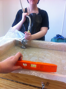 We fill the plastic with pulp and water and make sure it's level.