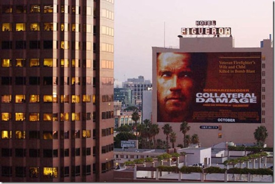 A movie billboard advertising Arnold Schwarzenegge...LOS ANGELES, UNITED STATES:  A movie billboard advertising Arnold Schwarzenegger's new film "Collateral Damage" about a bomb blast remains next to a downtown Los Angeles office tower, 12 September 2001. Warner Bros. today announced it was postponing the release of the film "in light of yesterday's tragic events and out of respect for the victims and their families."  Disney also announced it was postponing the release of a film about an attack on US soil called "Big Trouble."   AFP PHOTO/Lucy NICHOLSON (Photo credit should read LUCY NICHOLSON/AFP/Getty Images)