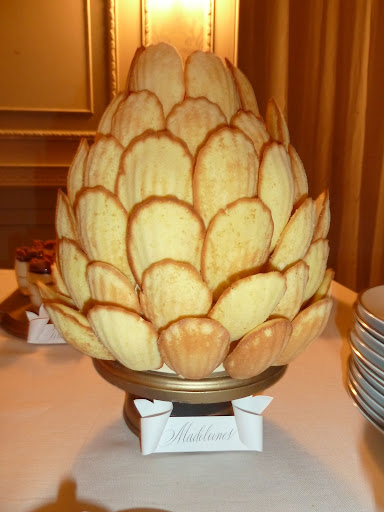 Madeleines were attached to two small cake foams with skewers. The shape mimics the icon by Bell'Ochio used on the invitation and favor packaging.
