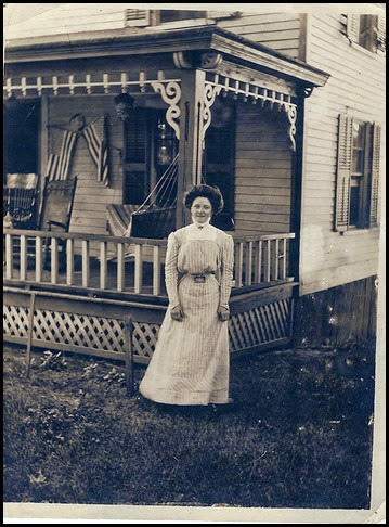 Lindsay_Marie in front of house with porch & flags circa 1912