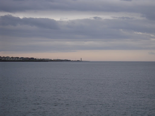 Early evening, looking out west from the city. That lighthouse is the westernmost object on the peninsula that holds Reykjavík.