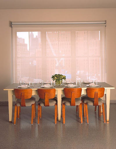 The dining table seats eight on Thonet chairs from the fifties. The table itself, a massive library table refinished with auto-body paint and a new linoleum top, seems to hover over the view south, toward the tip of Manhattan. The dining table seats eight on Thonet chairs from the fifties. The table itself, a massive library table refinished with auto-body paint and a new linoleum top, seems to hover over the view south, toward the tip of Manhattan.