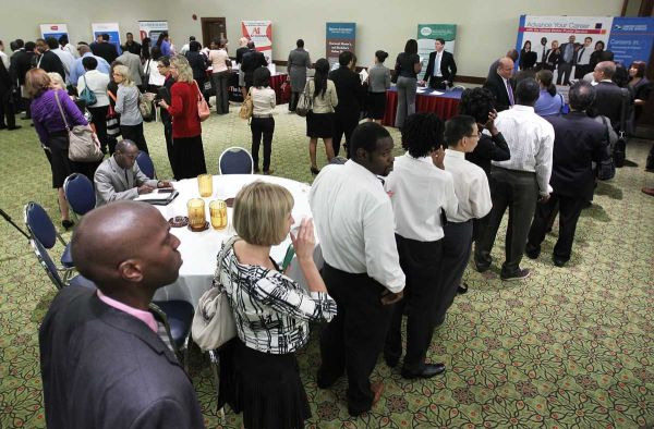 Job seekers line up in front of booths at a career fair hosted by National Career Fairs in Arlington, Va, 4 August 2011. Getty Images