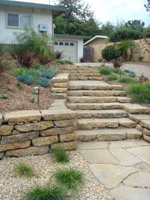 Our design added a generous stairway through the garden which welcomes visitors to the front door without forcing them to trudge up the driveway.