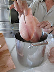 Martha places the tilapia in a large pot.