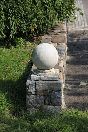 It looks just like one of the large, round, cement finials adorning the stone wall!