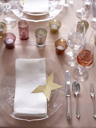 Set the table with simple pieces -- a peachy-pink tablecloth, glass dinnerware, off-white napkins -- to temper the bolder elements, like the mercury-glass candleholders and this gold-star napkin holder. (Martha Stewart Weddings) Set the table with simple pieces -- a peachy-pink tablecloth, glass dinnerware, off-white napkins -- to temper the bolder elements, like the mercury-glass candleholders and this gold-star napkin holder. (Martha Stewart Weddings)