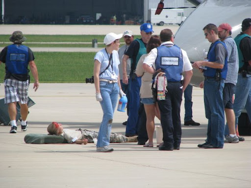 Actors posing as injured passengers in the drill wait for emergency responders to attend to them.