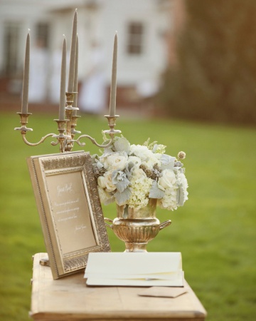 This guest book table, set out in the wide-open field where the ceremony took place, was decorated with an antique silver candelabra and a flower-filled urn. This guest book table, set out in the wide-open field where the ceremony took place, was decorated with an antique silver candelabra and a flower-filled urn.