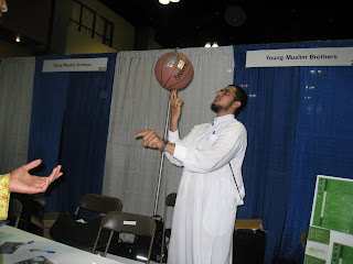 A brother spinning a basketball on his finger for a really long time at the YM Booth