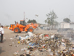 Un homme regardant un tas d'immondices déposés sur un terrain municipale de football à Kinshasa