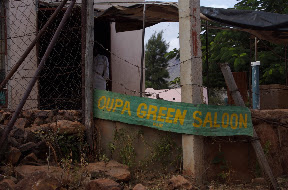Where the men go to get their hair cut. The difference between saloon and salon needs to be clarified here.