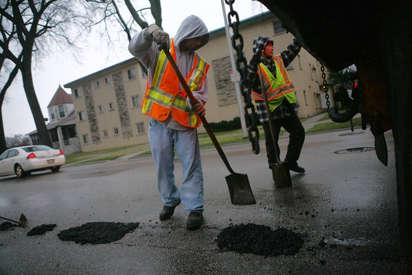 A crew repairs potholes Friday along Austin Boulevard on the West Side, part of a record-setting year of road repairs, 30 December 2011. E. Jason Wambsgans / Chicago Tribune