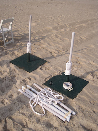 We buried umbrella stands in the sand for the ceremony structure and used the same tactic for poles along the aisle.