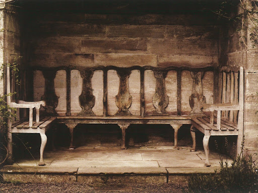 The details of this bench nestled in a stone nook are so charming and unique.
