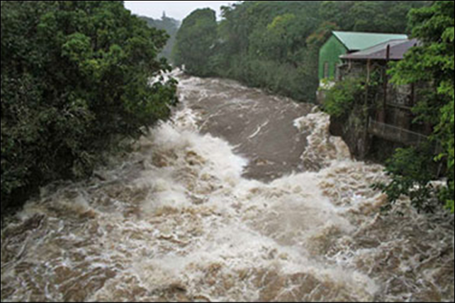 Floodwaters rush down Hilo's Wailuku River in 2000. Hawaii is seeing more frequent heavy storms, and climate change may be the reason, according to University of Hawaii researchers Ying Chen and Pao-Shin Chu. Photo: Hawaii Department of Public Works