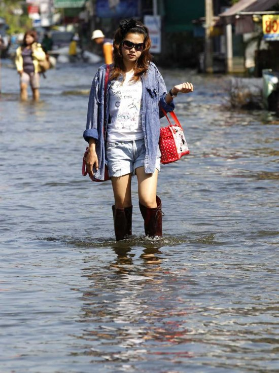 A Thai woman walks on a street with receding floodwaters in Bangkok, Thailand, 24 November 2011. Floodwaters have started to recede in Bangkok's northern suburbs but not in the western and eastern sections of the capital. The worst flooding in five decades has claimed over 600 lives and caused billions of dollars in damages industrial manufacturing plants, much of it foreign-owned and tourist sites shaving at least one per cent off the country's economic growth. RUNGROJ YONGRIT / EPA