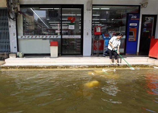 A Thai employee cleans up outside a grocery store as floods recede in Bangkok, Thailand, 24 November 2011. Floodwaters have started to recede in Bangkok's northern suburbs but not in the western and eastern sections of the capital. The worst flooding in five decades has claimed over 600 lives and caused billions of dollars in damages industrial manufacturing plants, much of it foreign-owned and tourist sites shaving at least one per cent off the country's economic growth. RUNGROJ YONGRIT / EPA