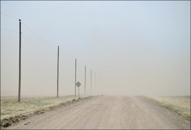 The relentless Kansas wind strips a dry, bare field and sends the topsoil to obscure a county road. Photo: Gil Aegerter / NBC News