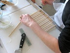 Here, she's completing the first step and measuring the width of the gum paste to fit the different tiers of the cake.