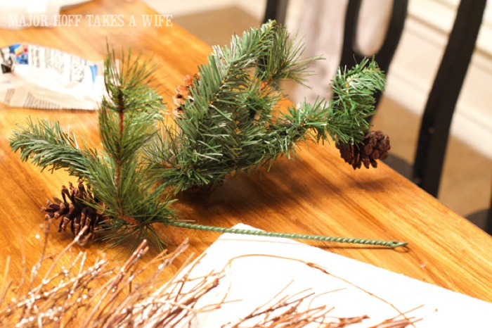 Bend the greenery to make it a better fit on the wreath. World Market inspired wreath. A fun twist on a Christmas wreath. Make a winter wreath that will last all season long and well past. This cute grapevine wreath is adorned with a tiny bird, pinecones, greenery and pom poms. You won't believe how cheap and easy this was to make! And so simple! #Christmas #winter #holiday #wreath #nature #knockoff Bend the greenery to make it a better fit on the wreath. World Market inspired wreath. A fun twist on a Christmas wreath. Make a winter wreath that will last all season long and well past. This cute grapevine wreath is adorned with a tiny bird, pinecones, greenery and pom poms. You won't believe how cheap and easy this was to make! And so simple! #Christmas #winter #holiday #wreath #nature #knockoff