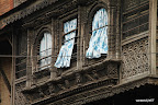 Blue curtains hanging from traditionally decorated Bhaktapur window