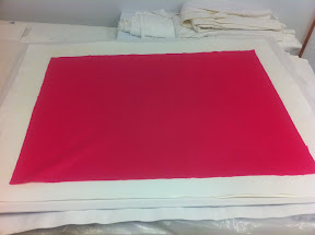 To dry the sheets, we layer them in between blotters and cardboard, and then stack them into a dryer system.