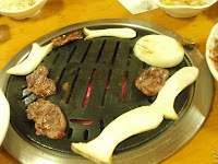 Meats, shrooms and onions grilling.