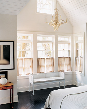 A high gable brings in brilliant light filtered by maple and hemlock trees. The faux-antler chandelier came from an antique market.