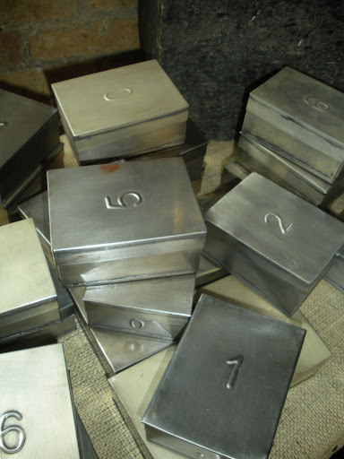 Numbered metal tins for collecting and organizing.