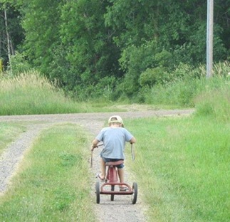 M riding an old trike at our farm "up north".