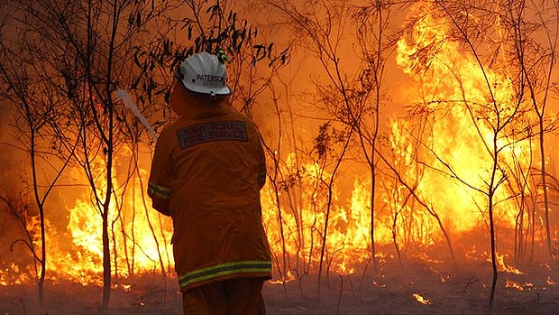 A firefighter in the New South Wales Rural Fire Service faces a brushfire, 7 January 2013. SMH