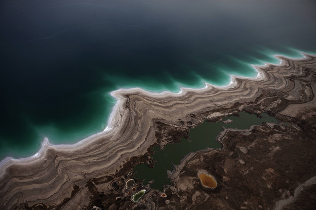 Aerial view of the Dead Sea's receding shoreline. About one-third of the Dead Sea’s natural surface area has disappeared and sinkholes are increasingly common as the restorative waters shrink amid drought, diversion of water for agriculture, largely from the Jordan River, and industry pumping. Menahem Kahana / AFP / Getty Images