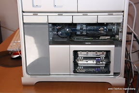 In der Mitte sieht man die Hauptplatine mit eingesteckter Grafikkarte; im unteren Schacht sind zwei ausziehbare Platinen mit den RAM-Speichern. Über der Hauptplatine sind vier Metallblenden, hinter denen Festplatten sind oder eingebaut werden können.