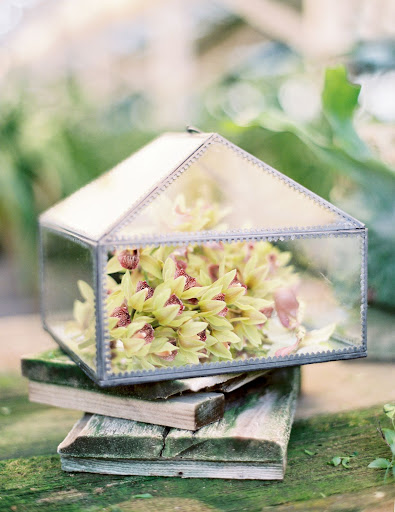 A mini greenhouse within a greenhouse: This peaked box holds orchids and would be a lovely element to include on your escort-card or guest-book table.