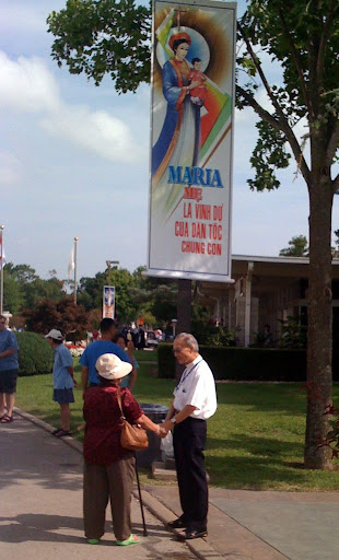 A priest visits with a woman during Marian Days.