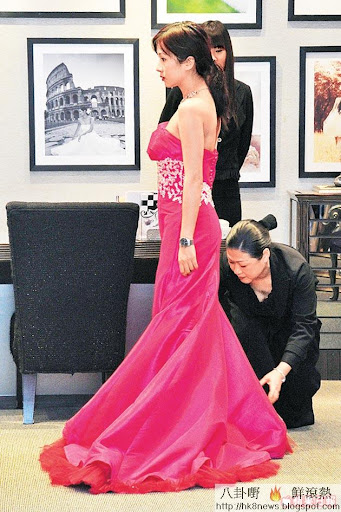 換上桃紅晚裝的文頌嫻,獲兩位工作人員殷勤服侍。
