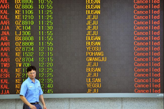 A man walks past an airport board announcing that all flights are cancelled following major typhoon Bolaven at Seoul domestic airport in Seoul on 28 August 2012. The state weather agency issued a typhoon warning on early 28 August 2012 for Seoul, the capital of about 10 million people, as the storm named Bolaven continued moving northwards. JUNG YEON-JE / AFP / Getty Images