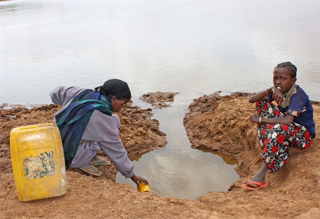Fetching water in the Borena zone in Ethiopia's Oromiya region. For Abdha Aso, a 20-year-old mother of five, it involves a four-hour round trip to a muddy pond. Only a year ago, she could reach a nearby stream in 20 minutes but it has since dried up. &copy; Jaspreet Kindra / IRIN