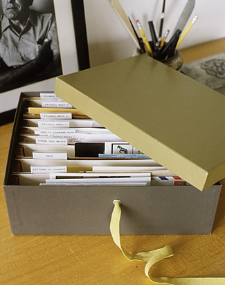 A recycled shoebox can be customized with a grommet and ribbon to hold mail and small papers.